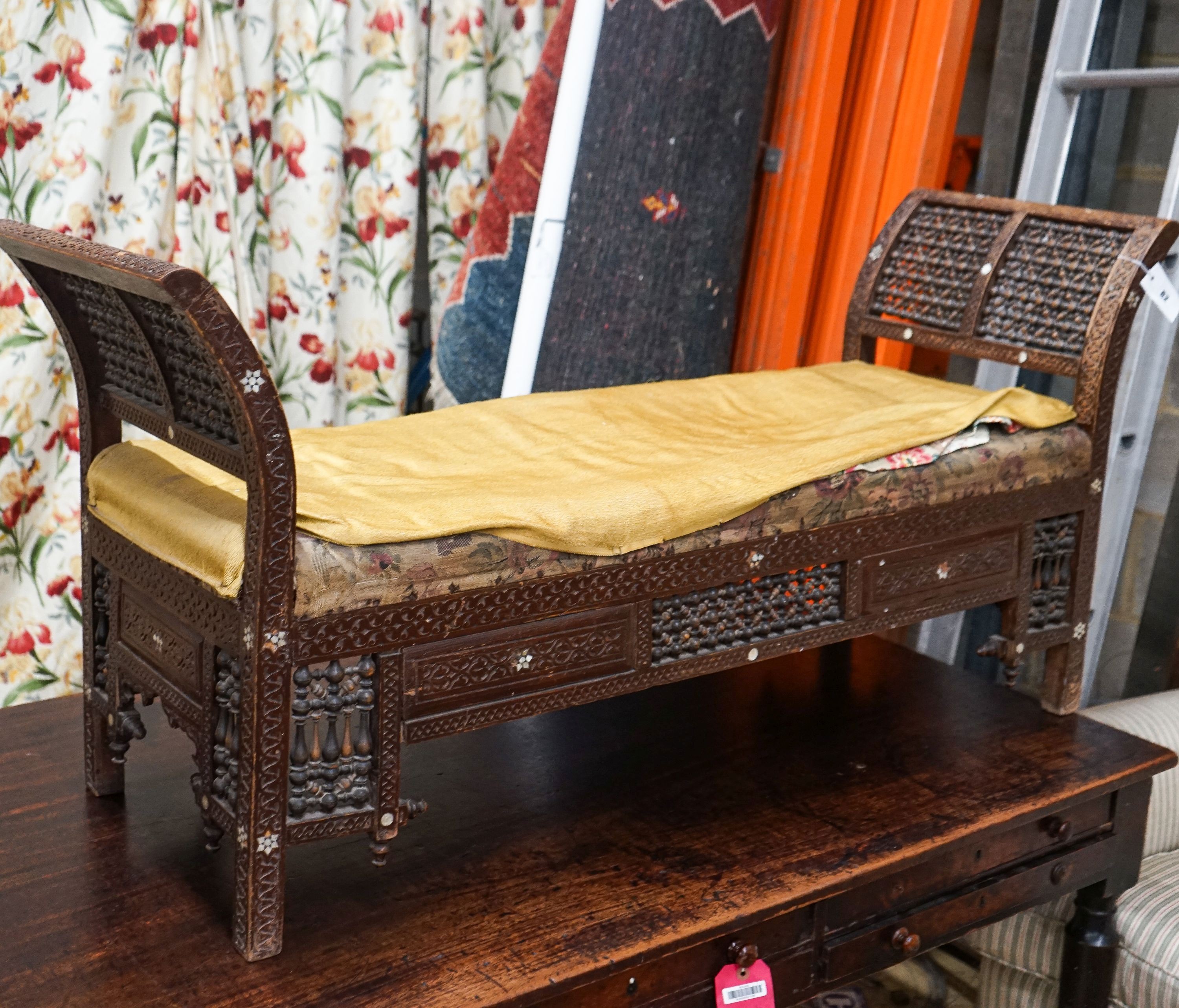 An early 20th century Moorish mother of pearl inlaid carved hardwood window seat, length 134cm, depth 44cm, height 64cm